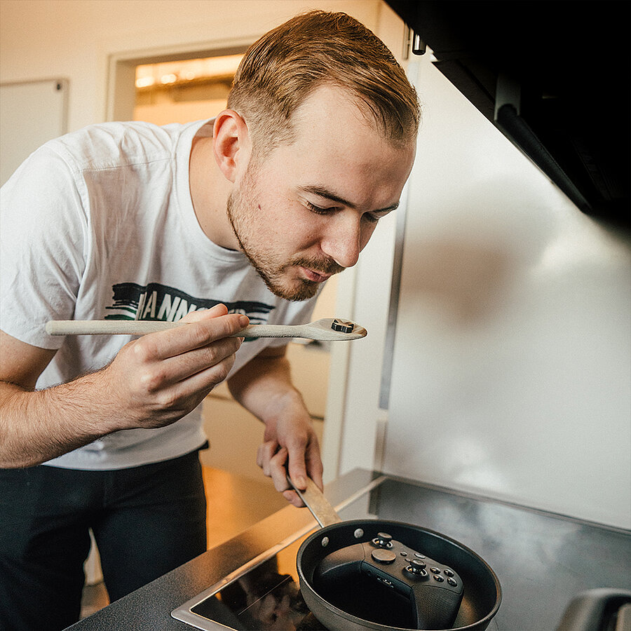Stefan, Performance Marketing Manager bei der B2B Digitalagentur digit.ly in Hannover, steht am Herd und probiert sein Essen.