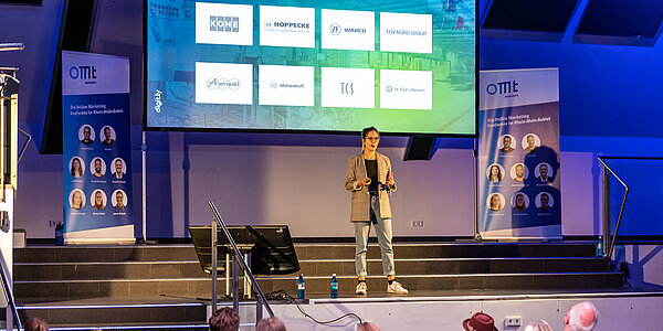 Speakerin von digit.ly, einer Agentur für Online Marketing in Hannover, steht auf der Bühne.